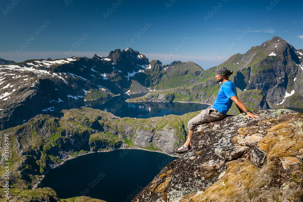 Man takes rest on top of mountain in Norway