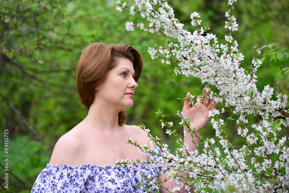 adult woman near the cherry blossoms adult woman near the cherry blossoms