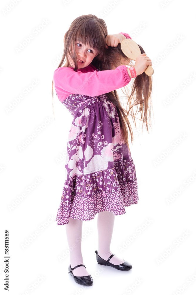 Little girl combing her frizzy hair Little girl combing her frizzy hair