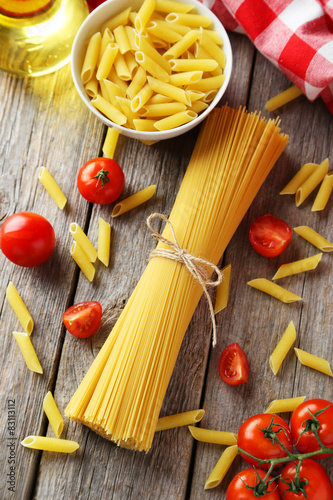 Spaghetti with pasta and tomatoes on wooden background