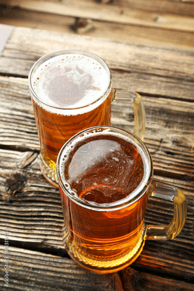 Two mug of beer on brown wooden background Two mug of beer on brown wooden background