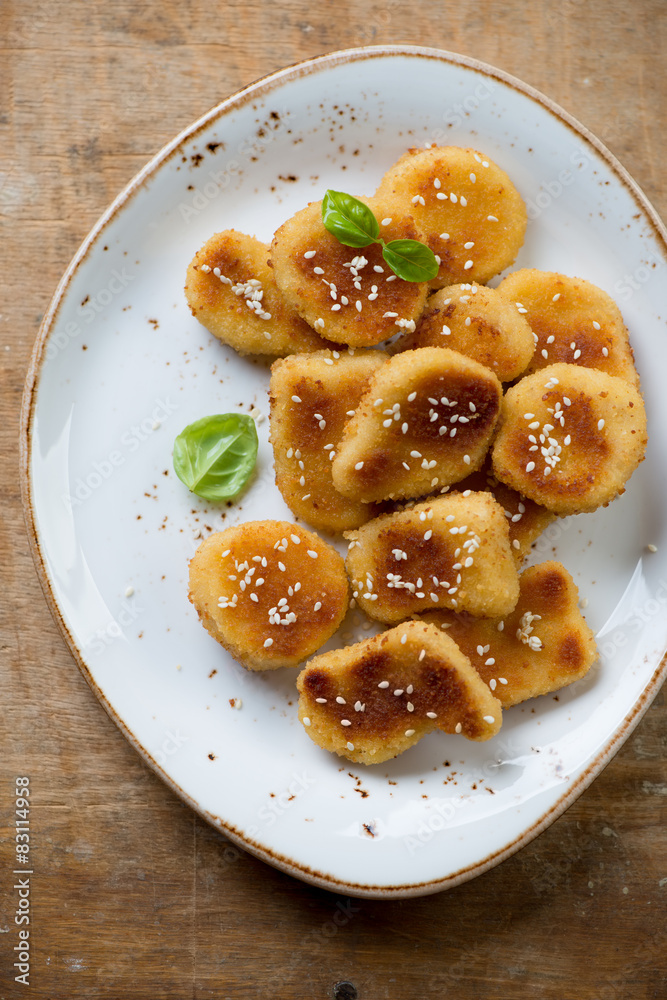 Above view of sesame chicken nuggets on a rustic wooden surface Above view of sesame chicken nuggets on a rustic wooden surface