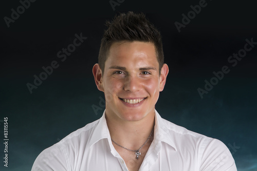 Headshot of smiling attractive young man in white shirt