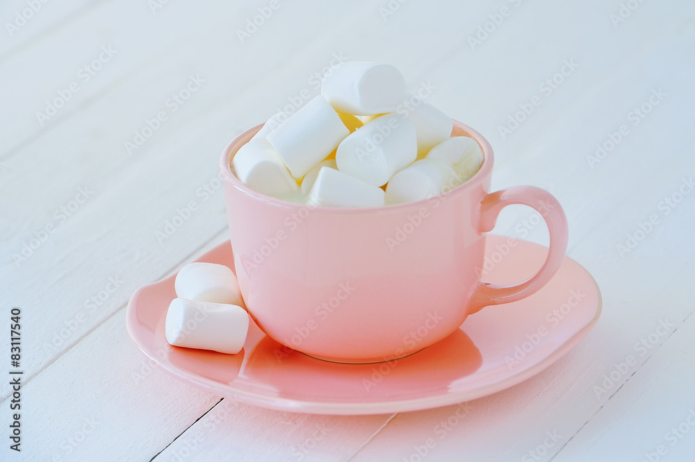 Porcelain pink cup full of white marshmallows Porcelain pink cup full of white marshmallows