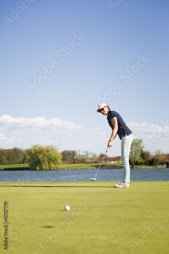 Female golf player putting.