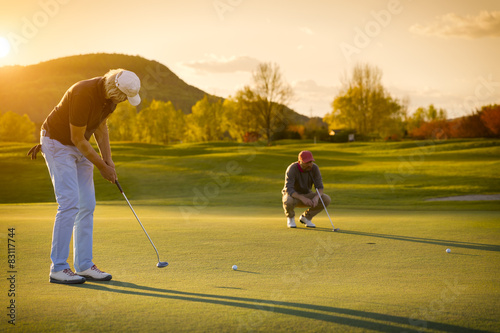 Two senior golf player at sunset.