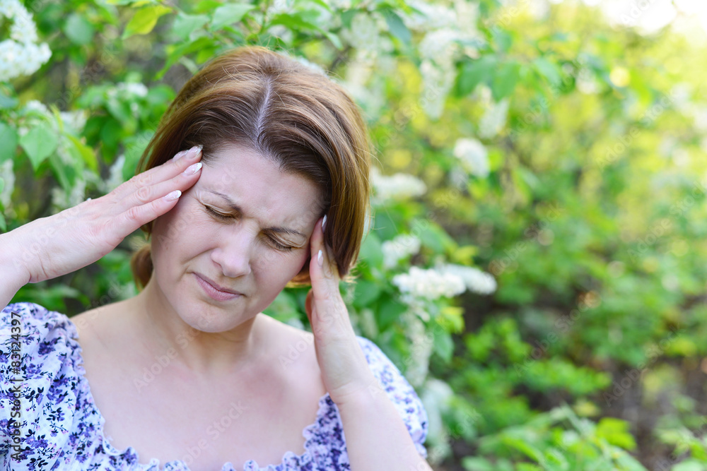 adult woman with headache about bird cherry blossoms in spring adult woman with headache about bird cherry blossoms in spring