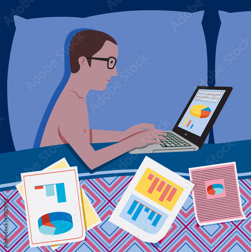 Man in bed at night working on the laptop