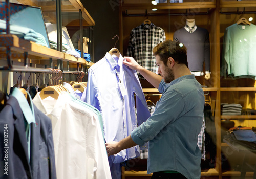 Young man shopping for clothes at store