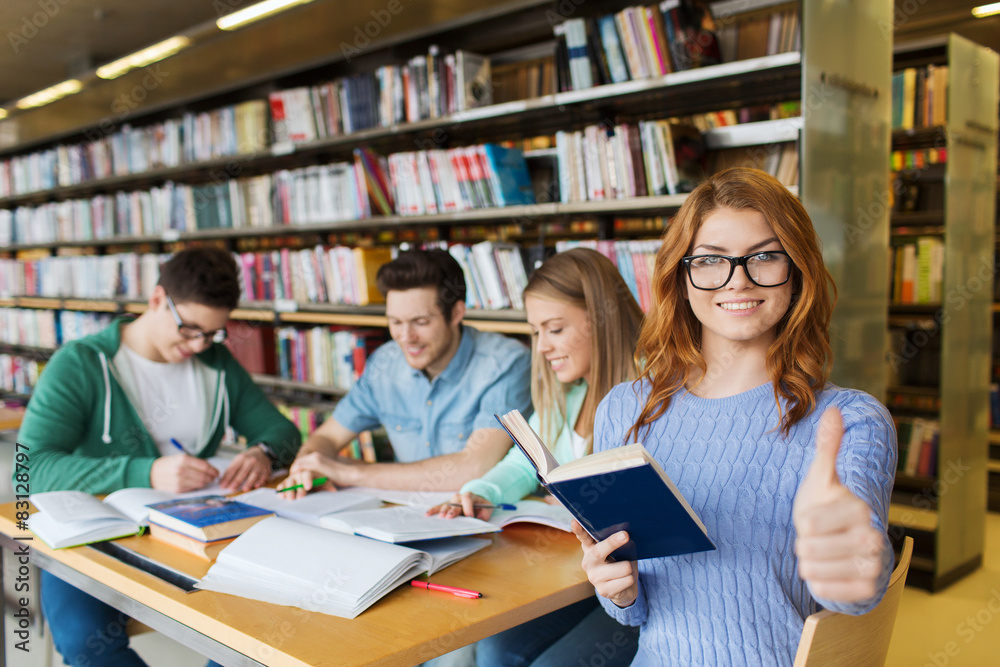 happy student girl showing thumbs up in library happy student girl showing thumbs up in library