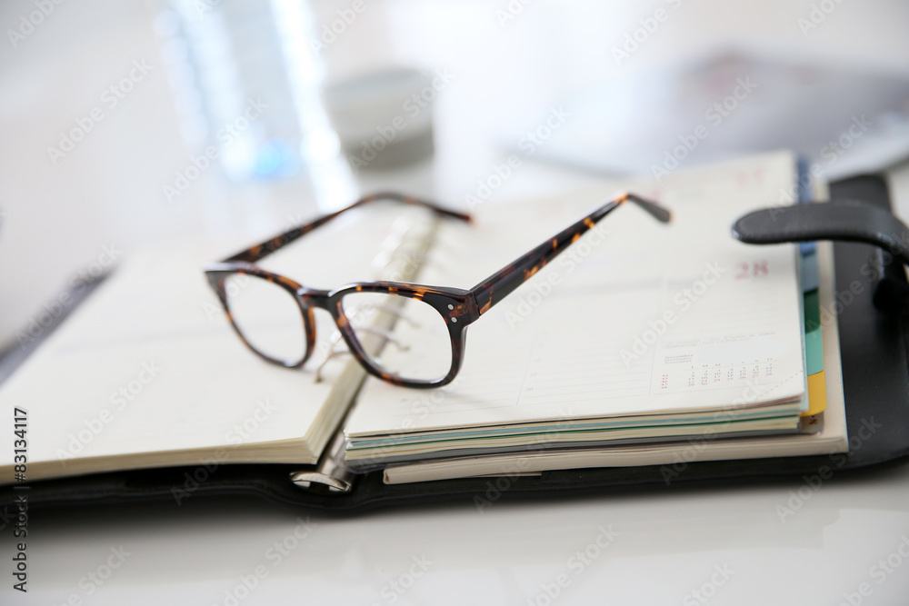 Closeup of eyeglasses set on business agenda Closeup of eyeglasses set on business agenda