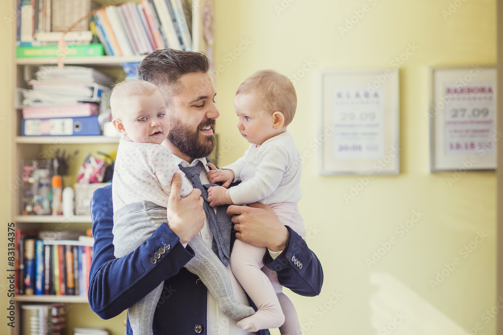 Fototapeta premium Young father hugging his daughter as he gets home from work