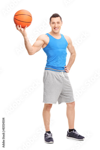 Handsome young man posing with a basketball in his hand