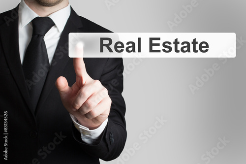 businessman pushing flat button real estate