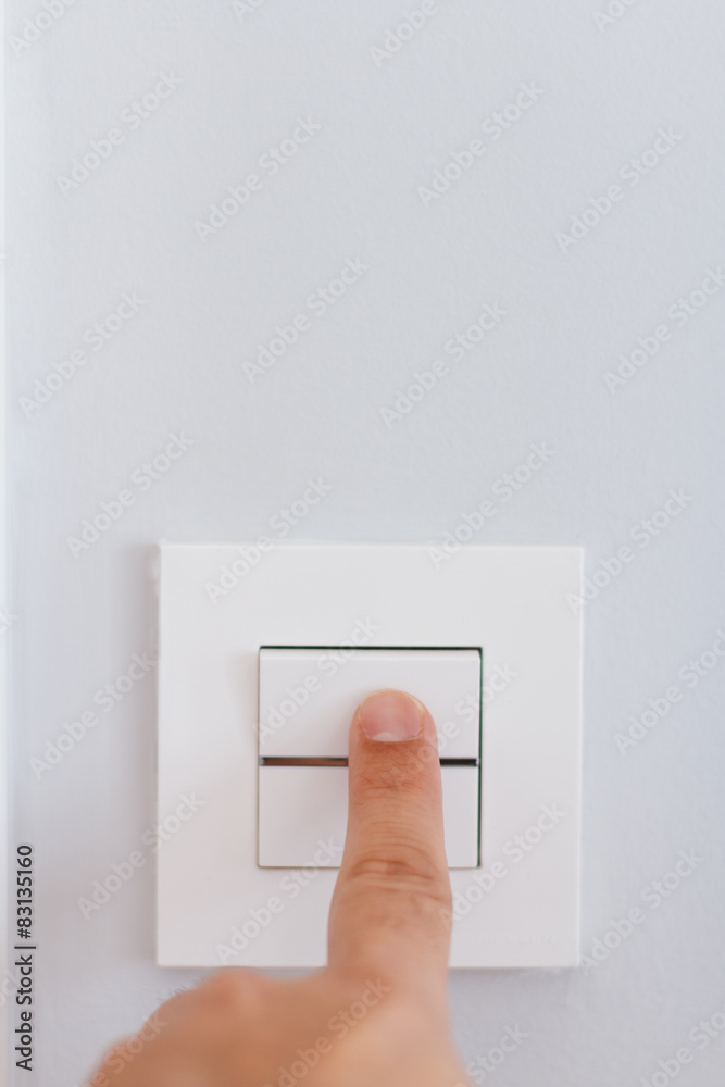 Hand with finger on light switch Hand with finger on light switch