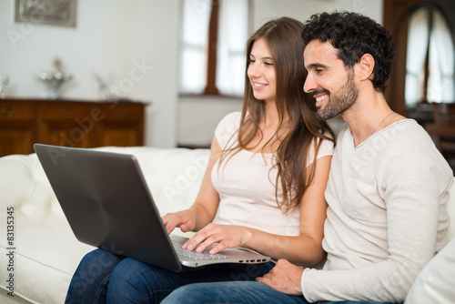 Happy couple using a laptop computer