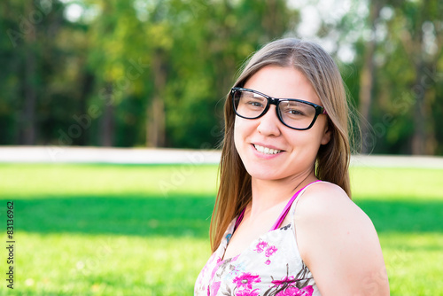Beautiful young woman with glasses in the park on the grass