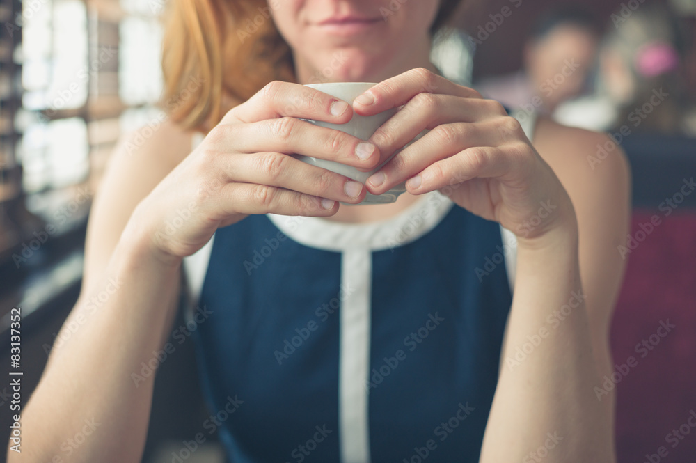 Fototapeta premium Woman having coffee by the window in a diner
