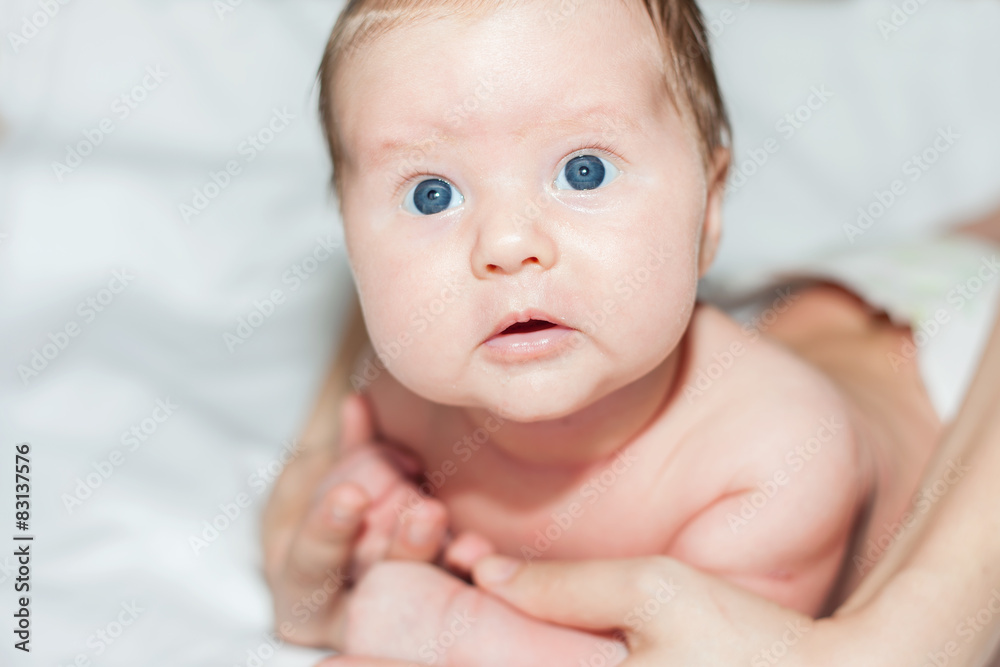 newborn baby girl lying on her stomach on a white bed newborn baby girl lying on her stomach on a white bed