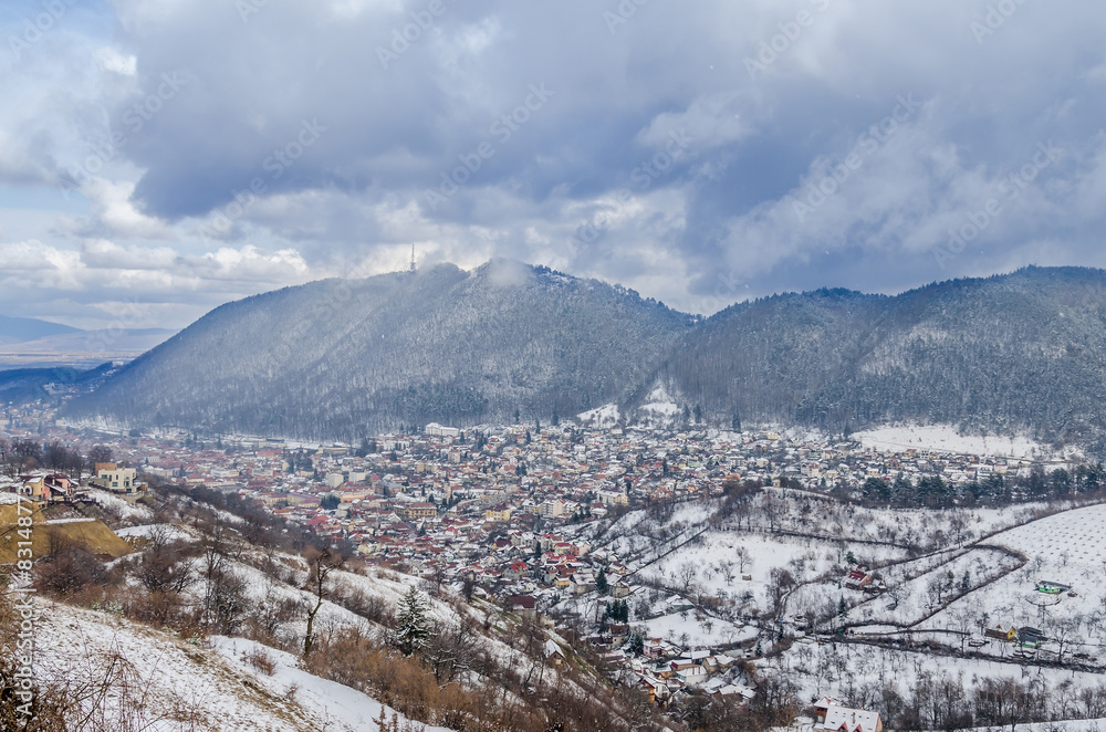 The Cityscape of Brasov City in winter time, cloudy day