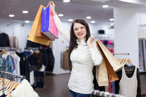Portrait of cute woman with shopping bags at fashionable store