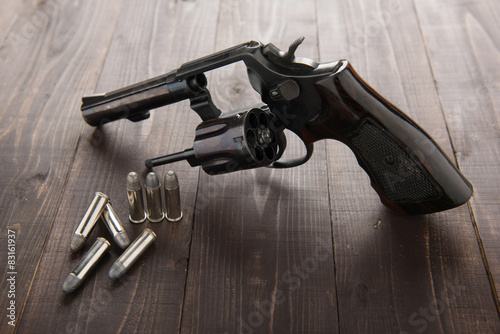 Obraz na plátně black revolver gun with bullets isolated on wooden background