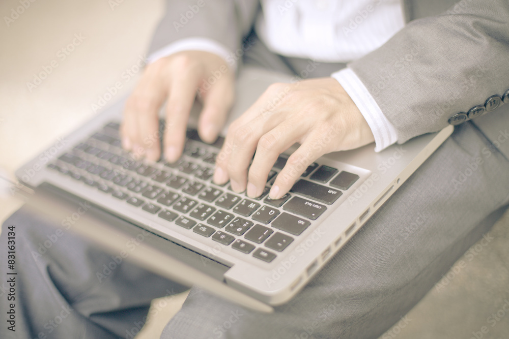 Businessman using laptop pc. He is sitting on a stairs. Businessman using laptop pc. He is sitting on a stairs.