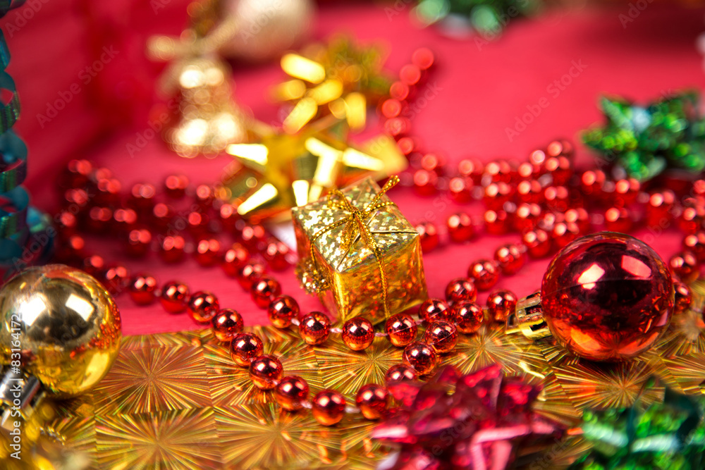 small golden gift-box near red bead and bow close-up small golden gift-box near red bead and bow close-up