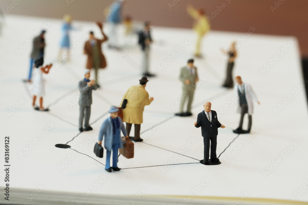 close up of miniature people with social network diagram on open close up of miniature people with social network diagram on open