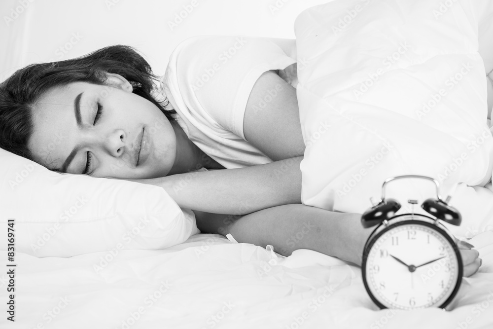 © Nonwarit - Woman in bed trying to wake up with alarm clock © Nonwarit - Woman in bed trying to wake up with alarm clock