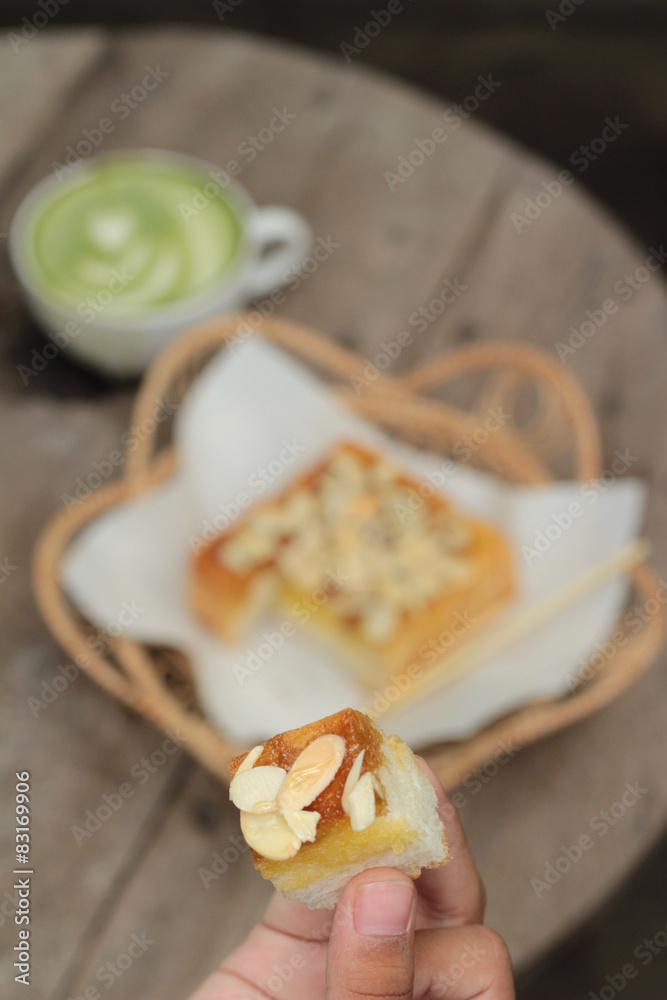Toast topped with almonds and honey in hand Toast topped with almonds and honey in hand