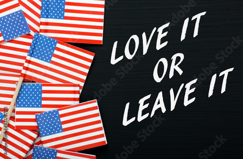 The phrase Love It or Leave It on a blackboard with USA flags