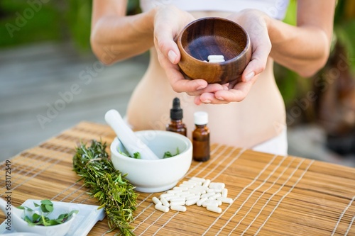 Obraz na plátně Fit woman showing bowl of pills