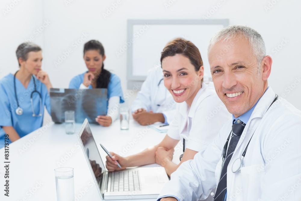 Team of doctors working on laptop and analyzing xray Team of doctors working on laptop and analyzing xray