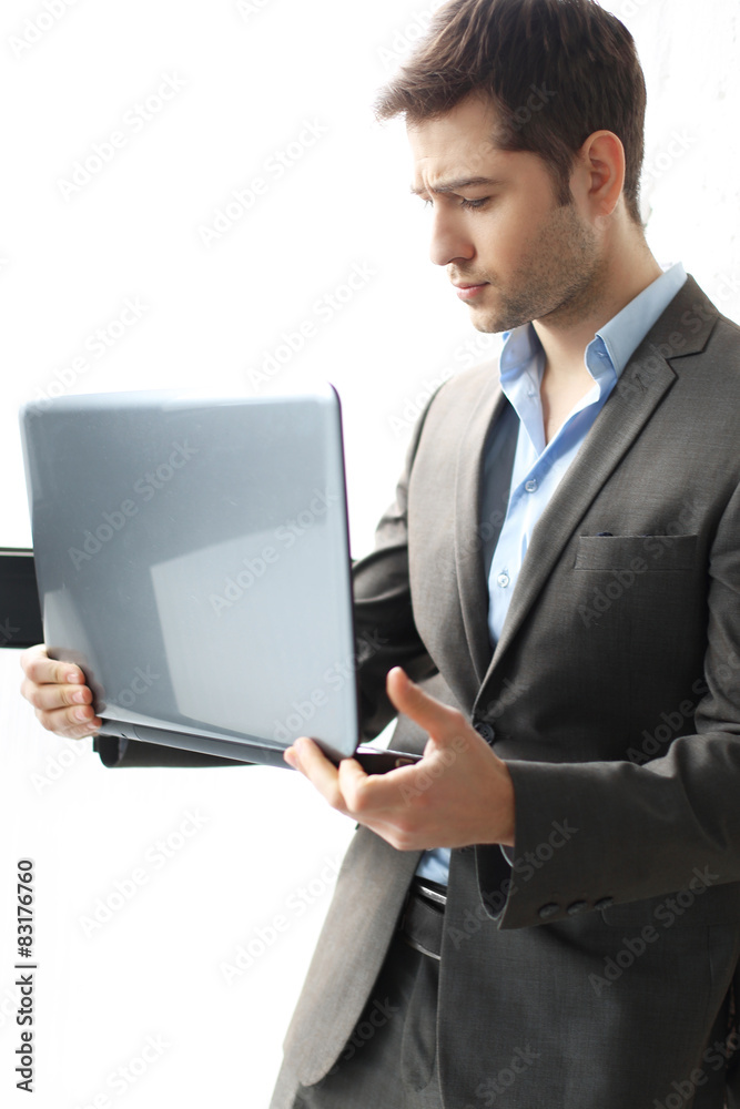 Biznesmann. Mężczyzna w garniturze pracuje z komputerem - obrazy, fototapety, plakaty 