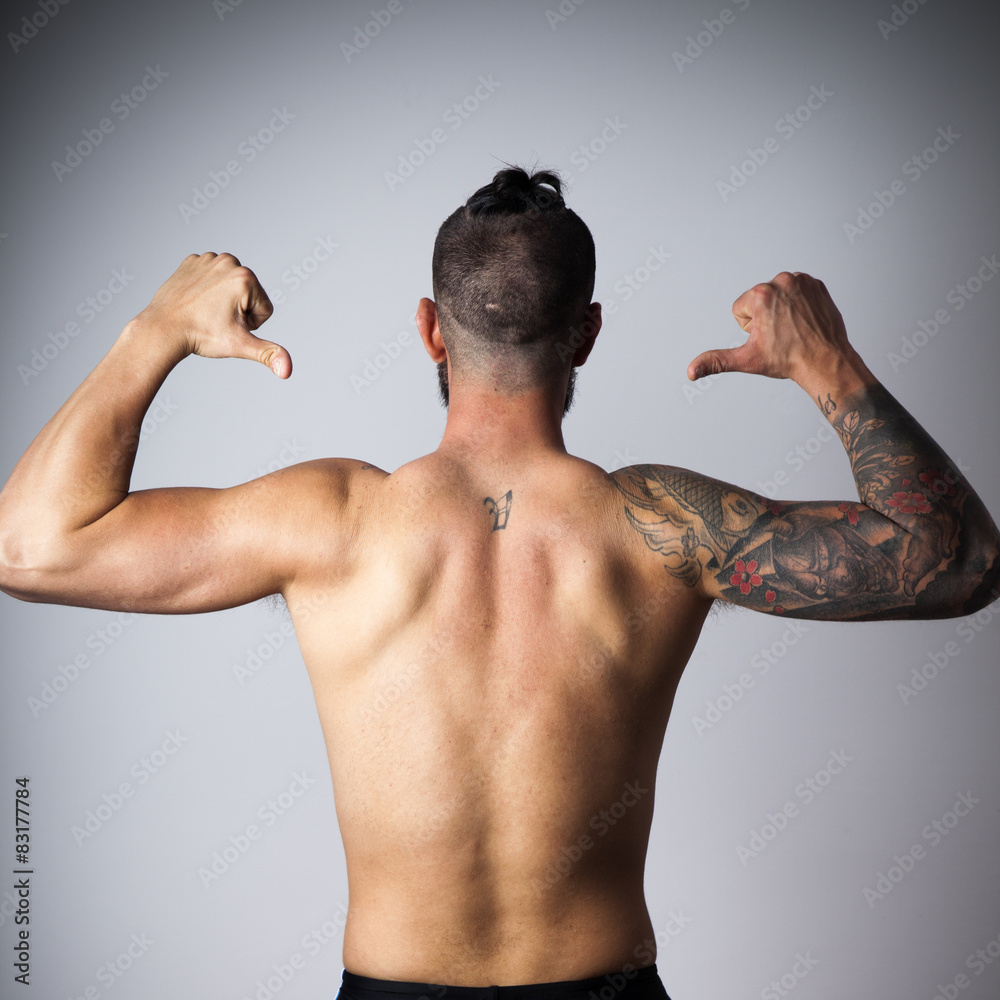 Foto de Espalda de hombre con brazo tatuado do Stock
