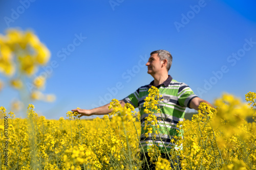 happy man in the rapeseed plantation, look the blue sky  © MTaitas