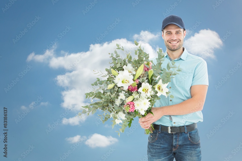 Composite image of happy delivery man holding bouquet Composite image of happy delivery man holding bouquet