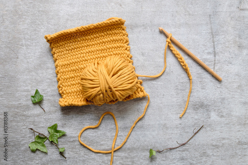 Ball of yellow yarn with crochet hook