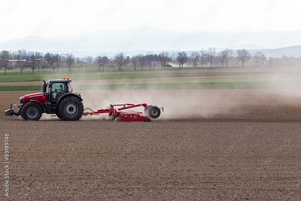 Fototapeta premium Tractor harrowing the field