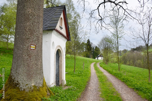 Country road with old chapel and tourist sign, Orlicke hory. photo