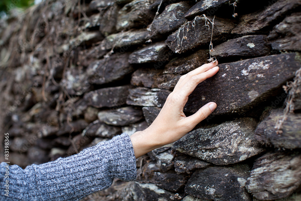 Touching the stone wall women hand