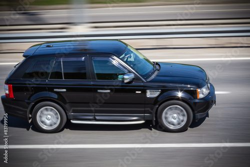 Fototapeta black Range Rover  quickly goes on the road