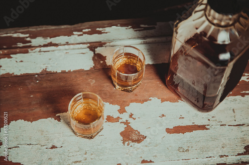 Two glasses of whiskey standing on the bar