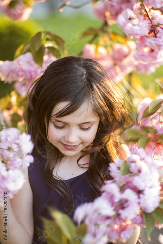 Small girl amid cherry bloom