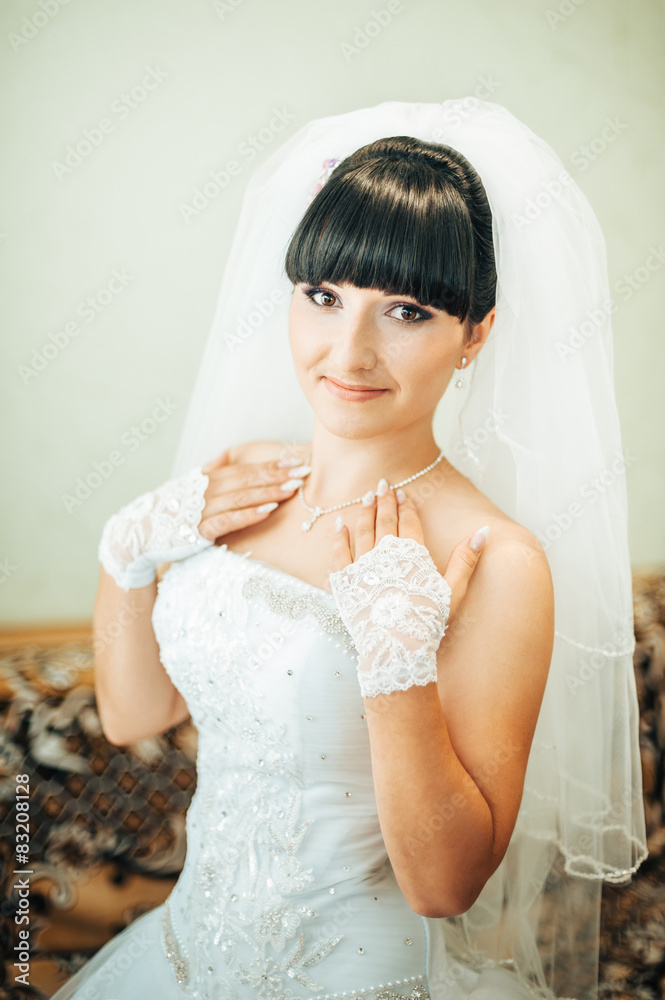 beautiful bride getting ready in white wedding dress with