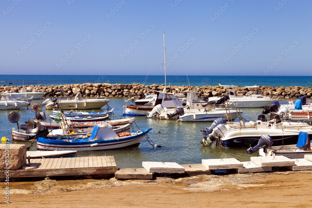 Fishing boats in a small sea port in enclosed rocky marina