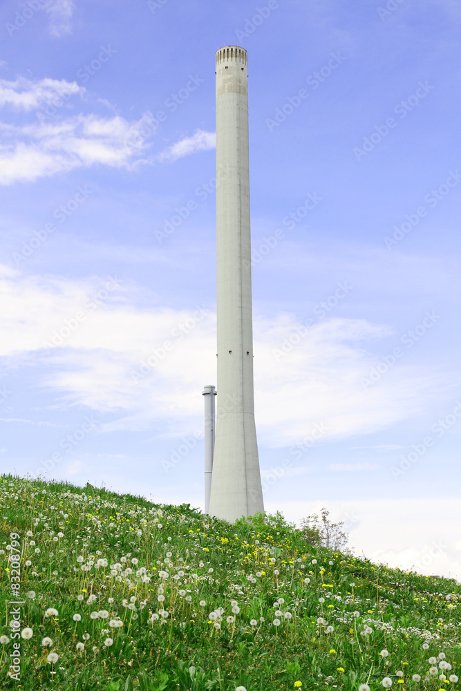 a high concrete chimney with white smoke clouds blue sky a high concrete chimney with white smoke clouds blue sky