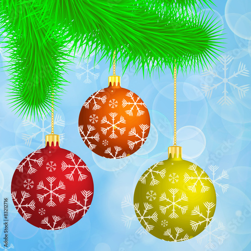 Christmas branch with hanging christmas balls on the blue bokeh