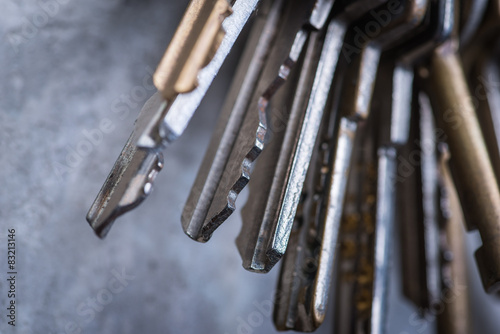A bunch of old worn keys on the grey concrete wall © Room 76 Photography